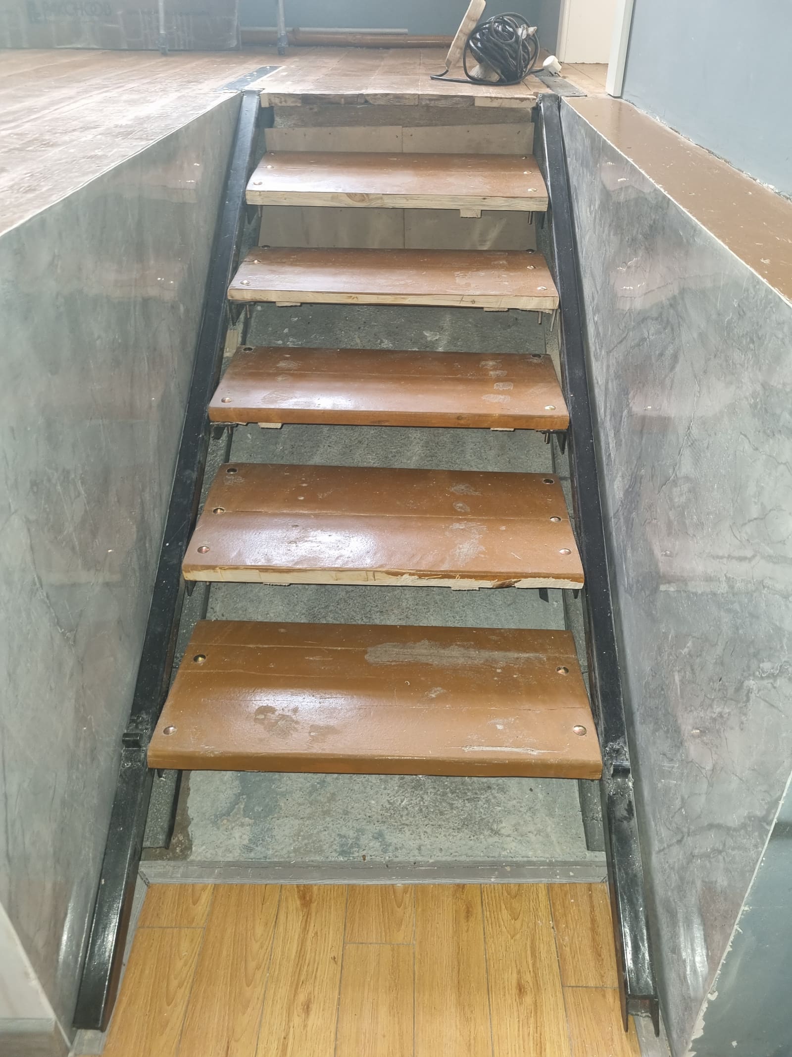 Deployed stair from the lower office level, showing painted treads on the welded steel linkage