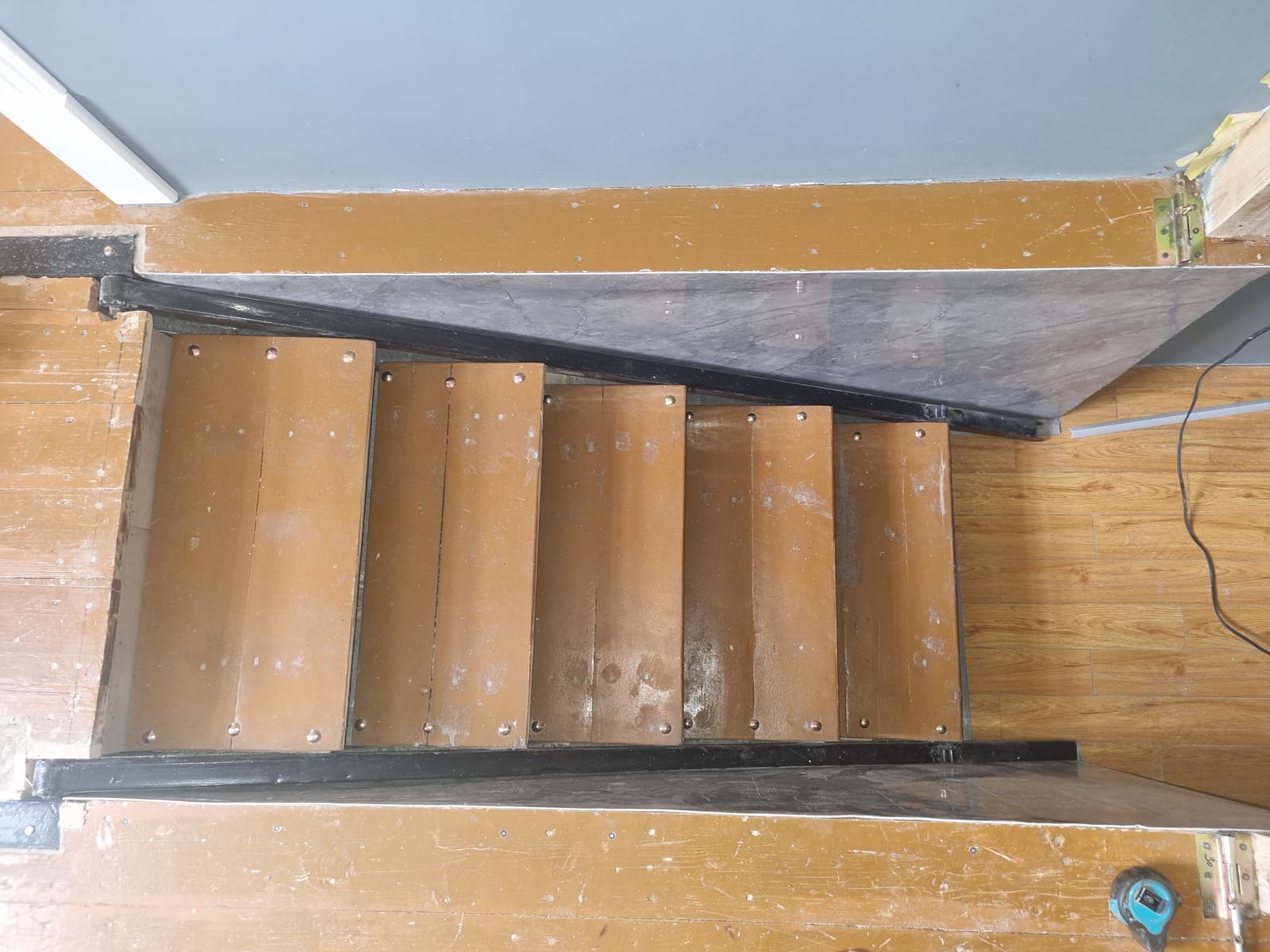 Deployed stair seen from the top landing, treads stepping down to the office level